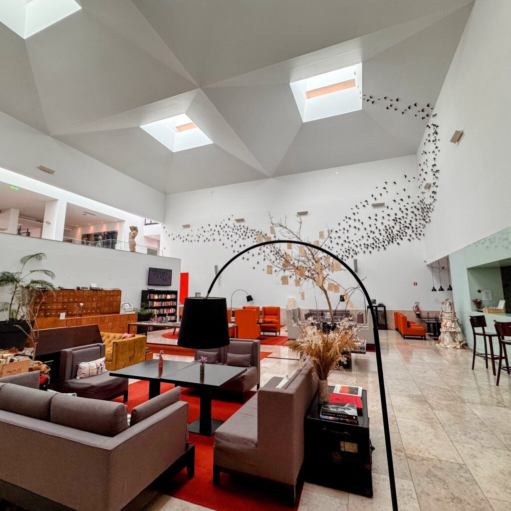 Modern lounge area of a Portugal small hotel, filled with comfortable sofas, designer lighting, and a relaxed atmosphere.